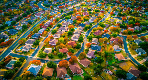 Autumn fall colors high above a modern suburban housing development, aerial drone view