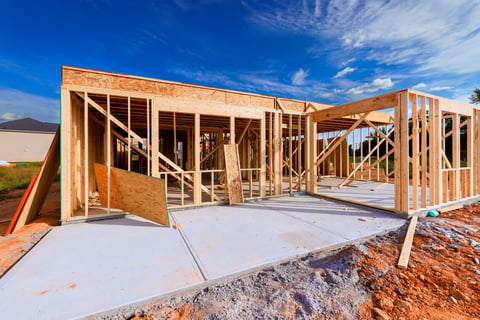 Workers are constructing wooden beams frame for new house at construction site