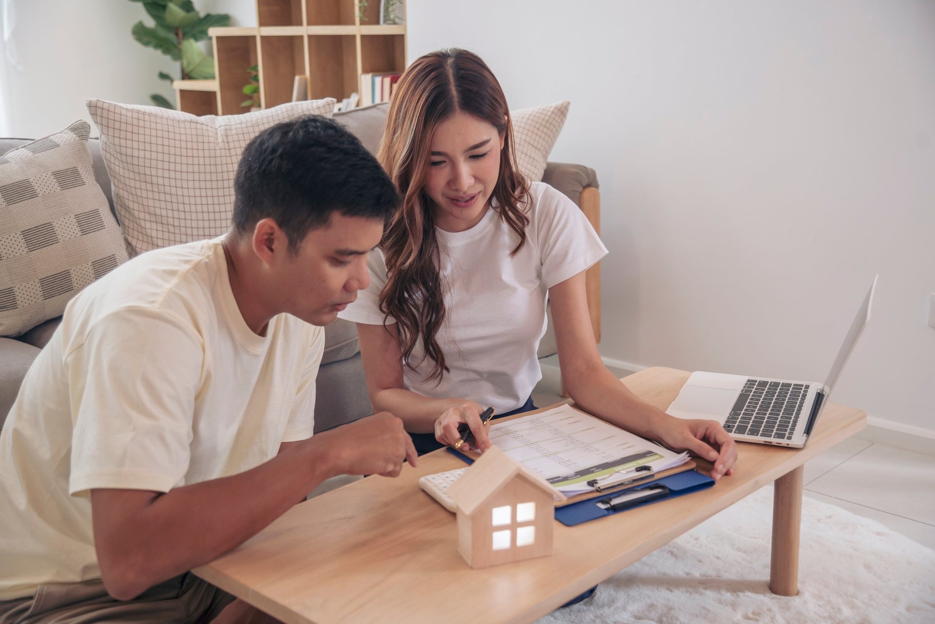 Couple lover make home financial plan. Young asian lover planning retire plan at home bedroom look at investment graph chart. Family finance investment happy together.